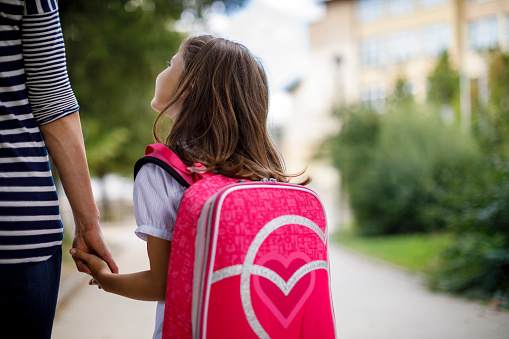 Mother taking her daughter to school